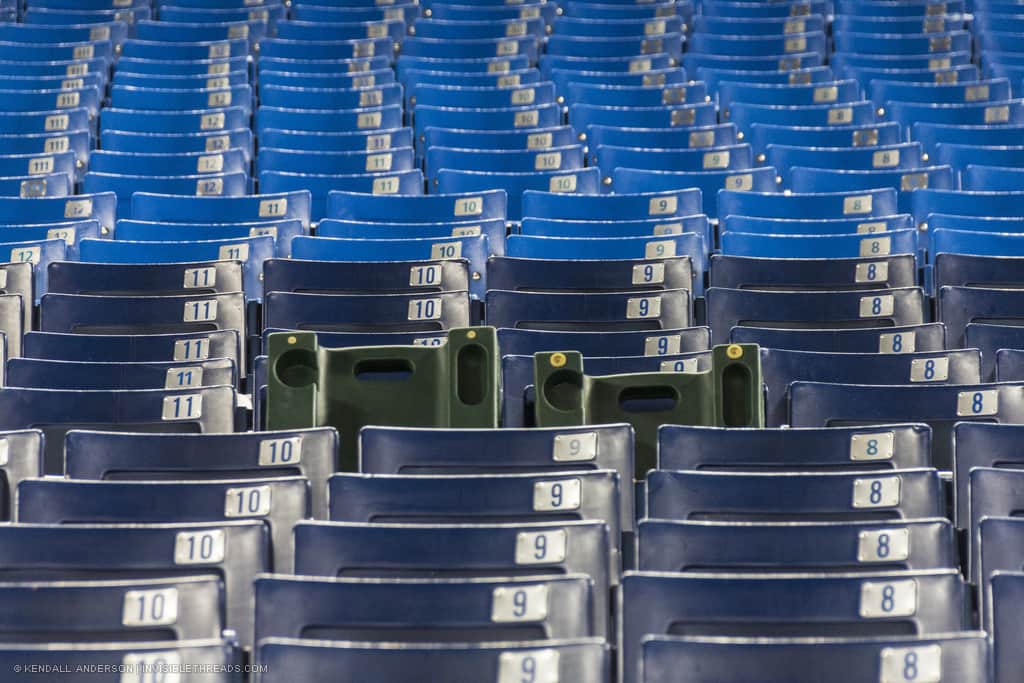Numbered baseball bleacher seats seen as a patterned array of chair backs stretching into the distance