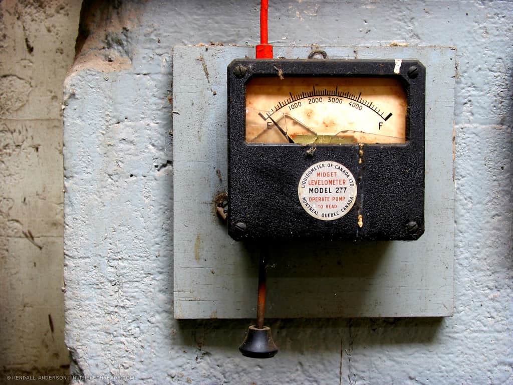 A piece of equipment with a gauge is mounted to the wall. The equipment has a label reading 'Midget Levelometer'.