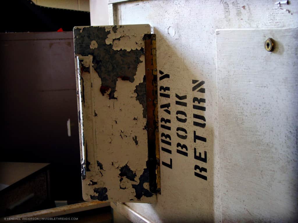 A white box labelled 'Library Book Return' is overturned and on the floor.