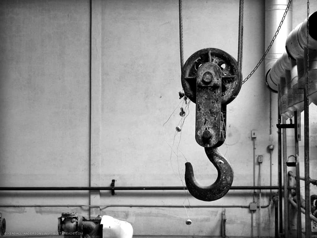 A large metal hook is attached to a cable and pulley, suspended from the ceiling.
