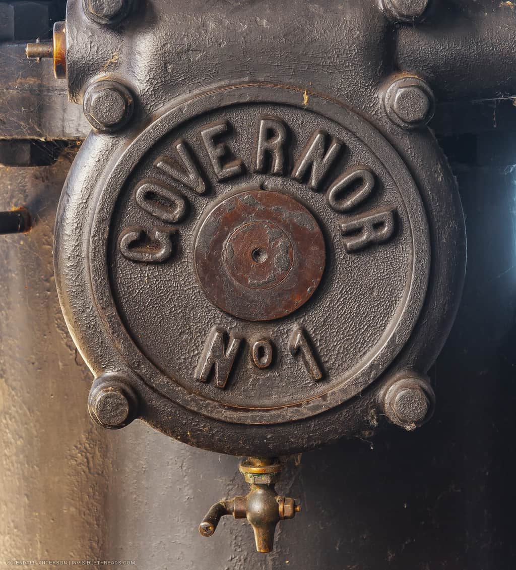 A textured steel disc has a small spout on the bottom. The steel disc has the words 'Governor No 1' embossed on it.