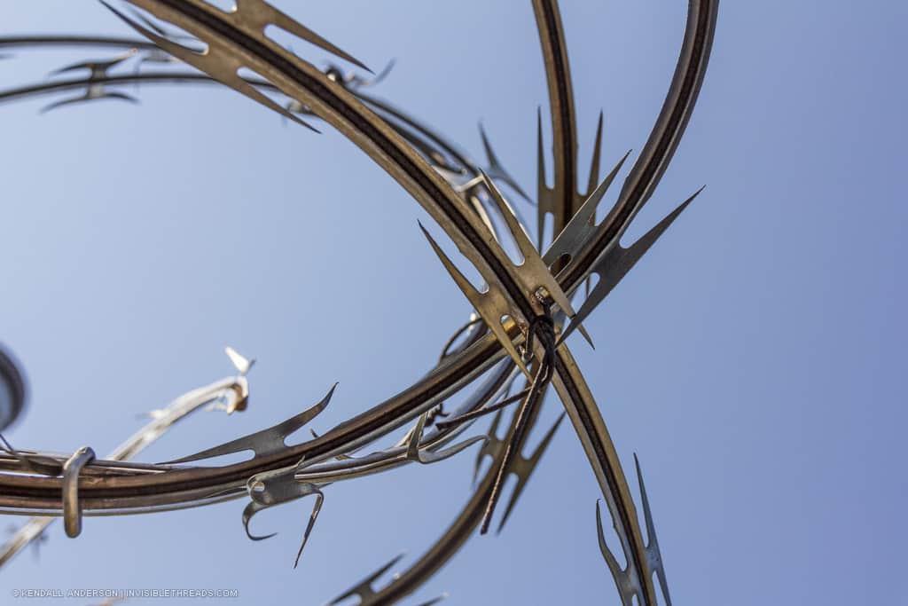 Close-up detail of razor wire fence, with sharp pointy edges