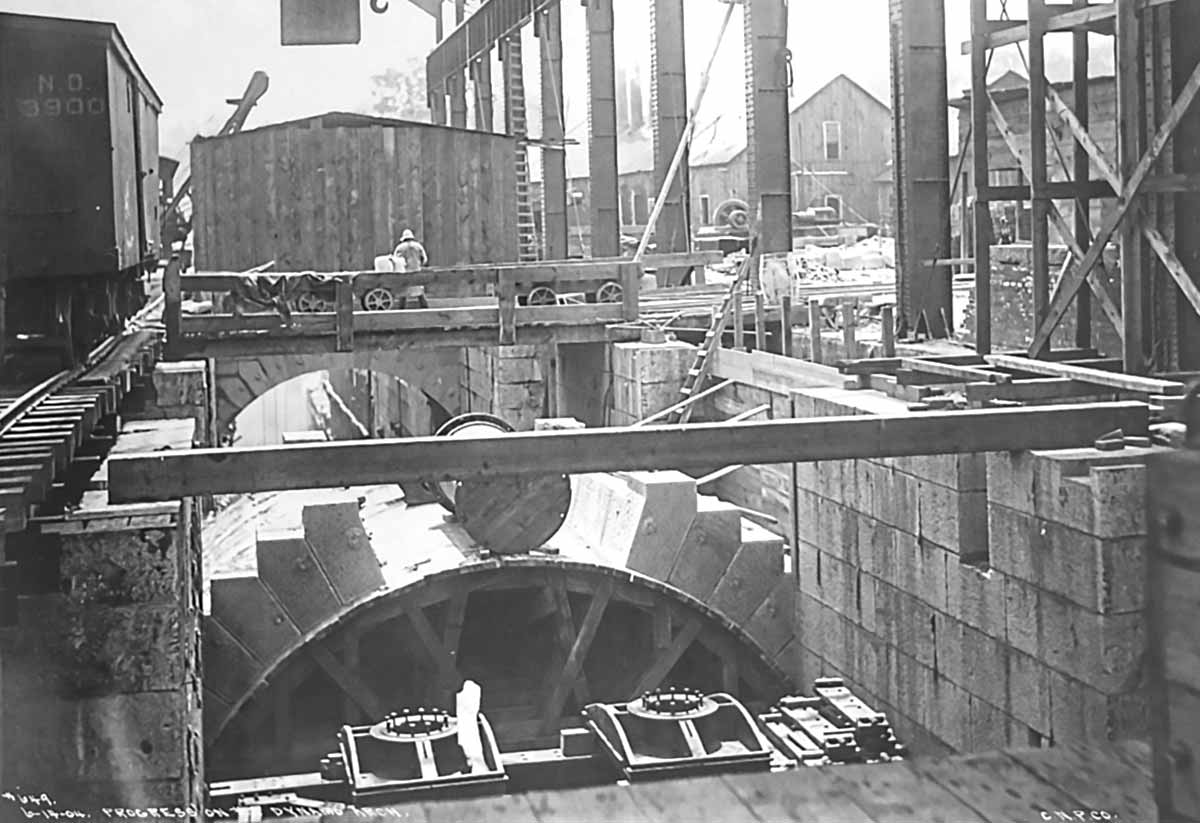 Archival photo 1904 showing construction of the stone arch below ground that supports the weight of the alternators in the Power House. The stone arch is in mid-construction, and supported by a timber frame below to provide the arch shape.